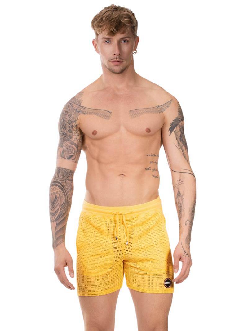 Man wearing yellow checkered shorts on a white background
