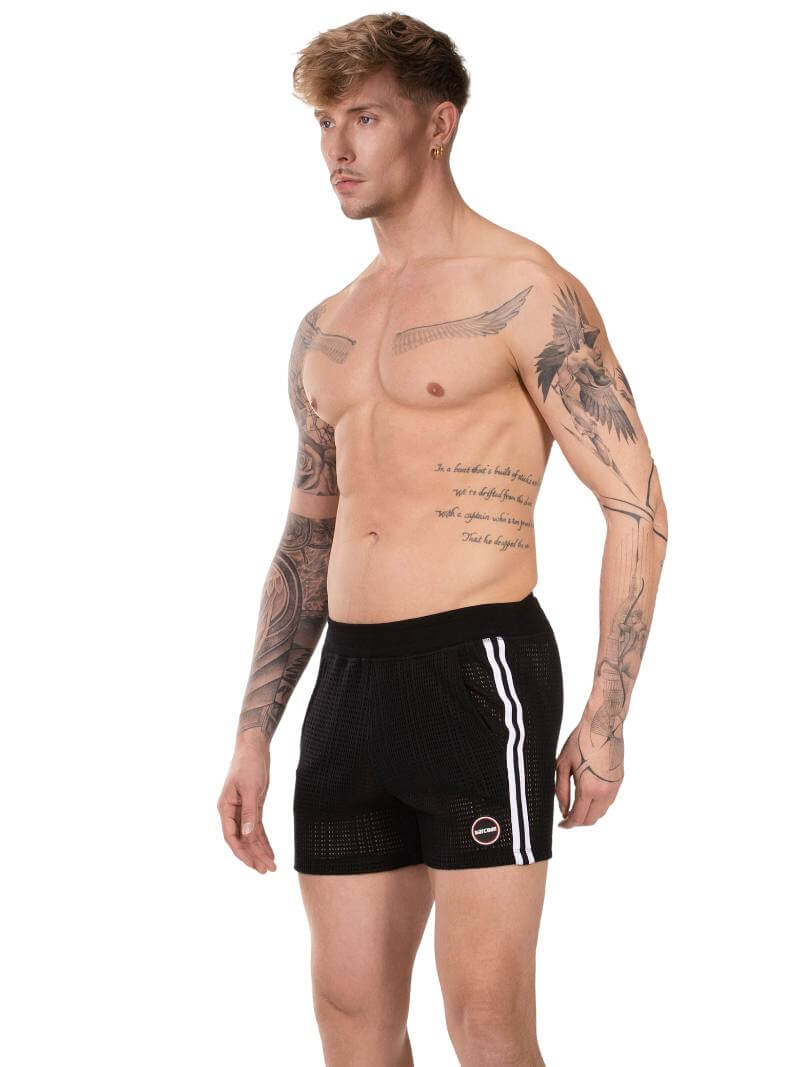 Man wearing black shorts with white stripes on a white background