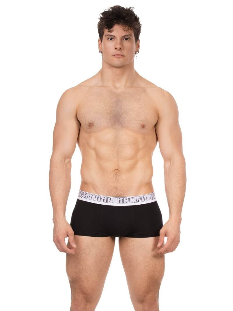 Man wearing black boxer briefs with a white waistband on a white background