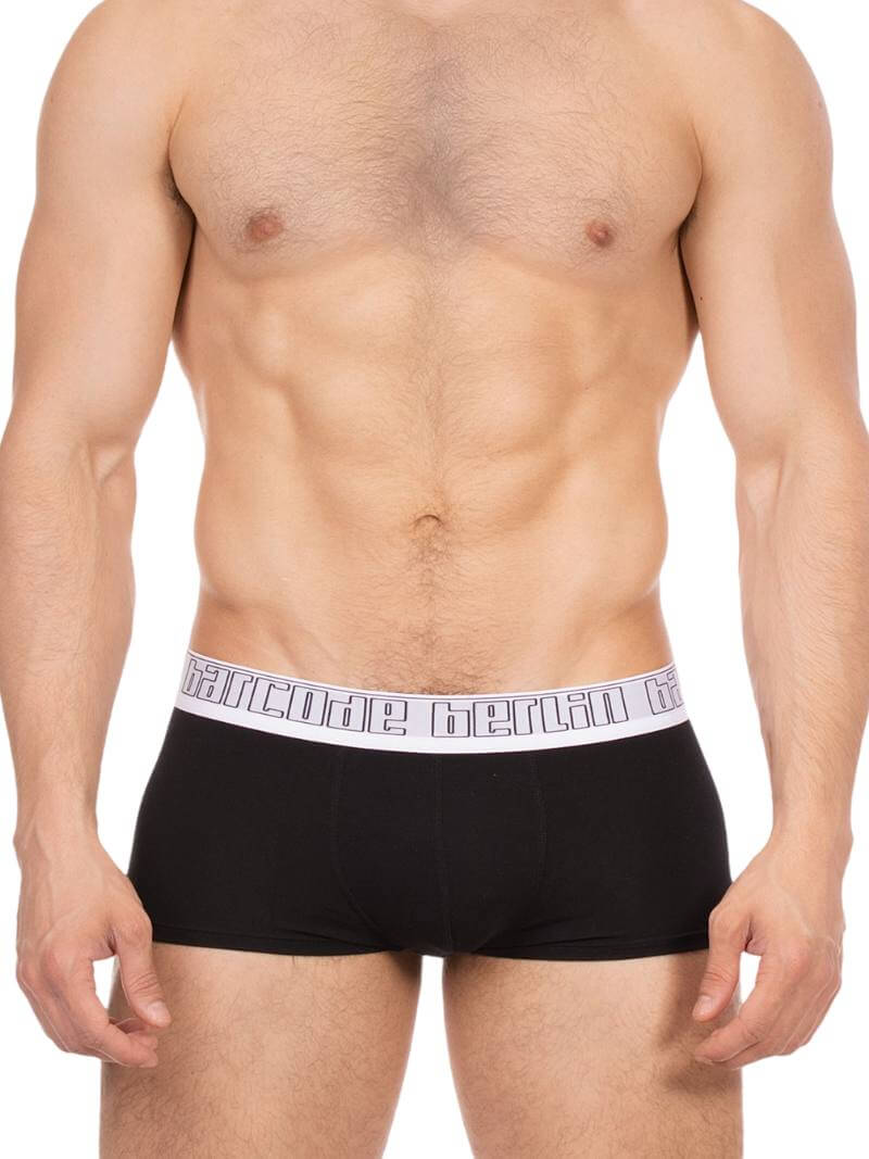 Man wearing black boxer briefs with a brand logo on the waistband against a white background