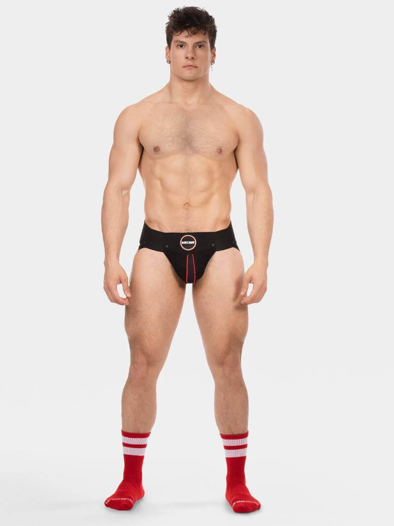 Man wearing black underwear with red accents on a white background