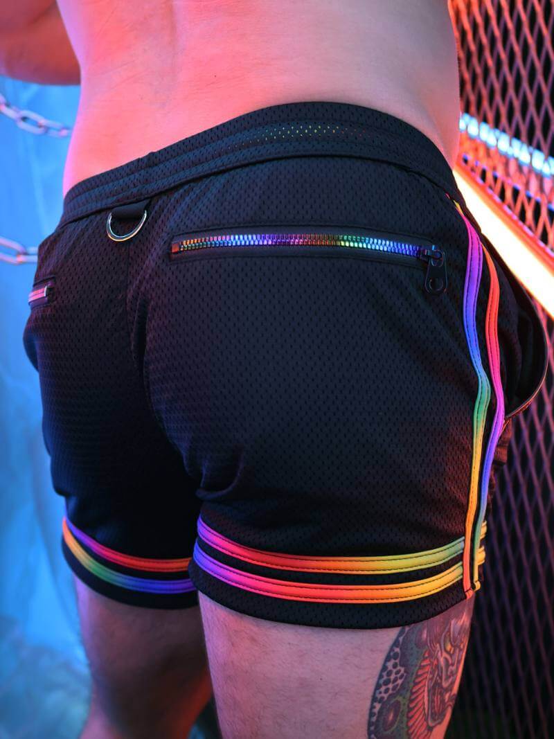 Black shorts with rainbow stripes and zippers on a person against a blurred background
