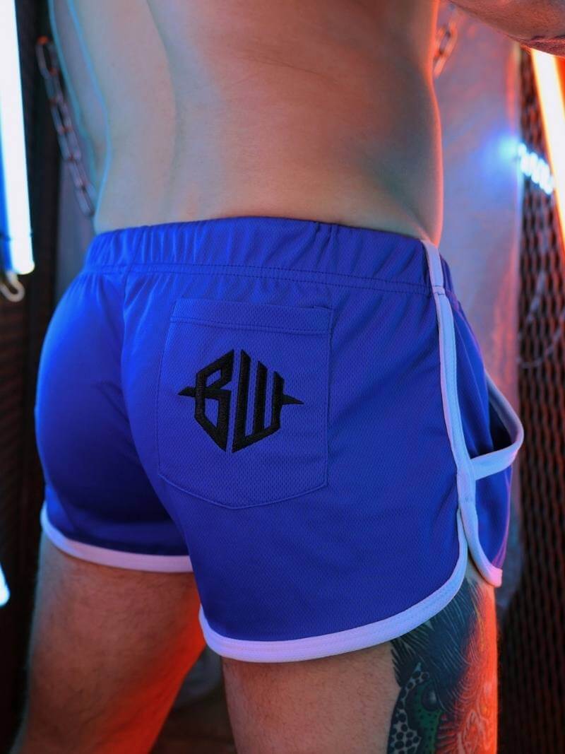 Blue swim shorts with a logo on the back, worn by a person.
