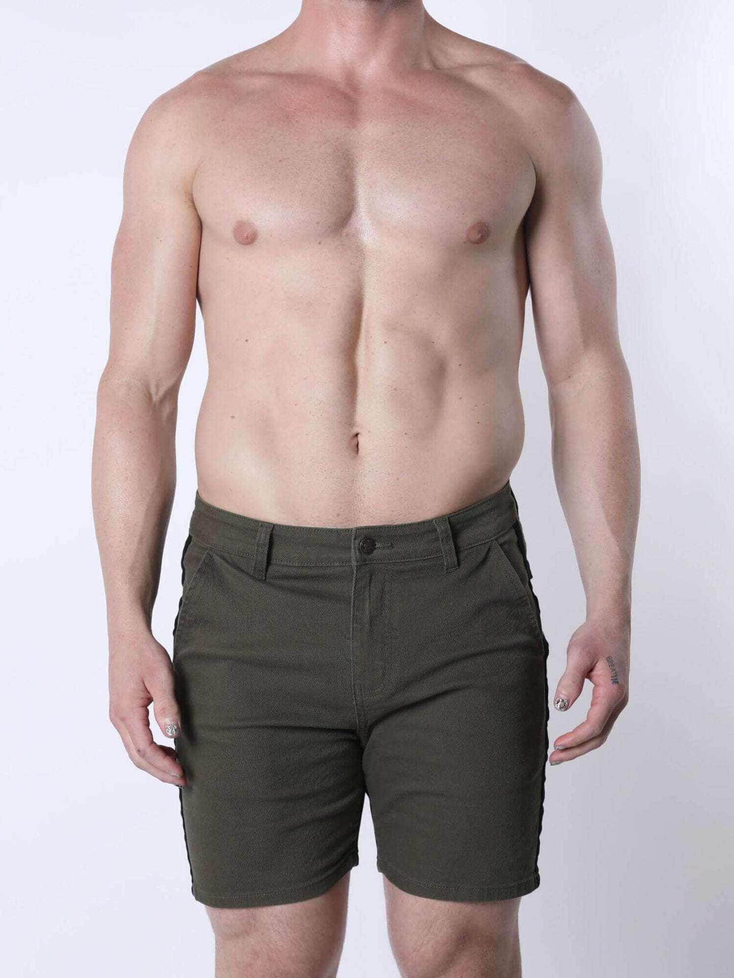 A shirtless male model wearing olive green shorts, shown from the waist down against a plain light gray studio background.