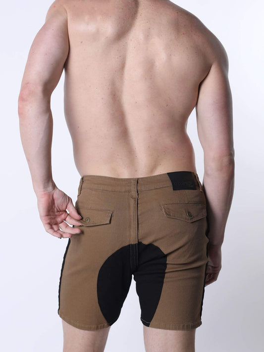 Rear view of a shirtless man wearing tan shorts with black contrast panels and black side stripes, photographed against a light gray studio background.