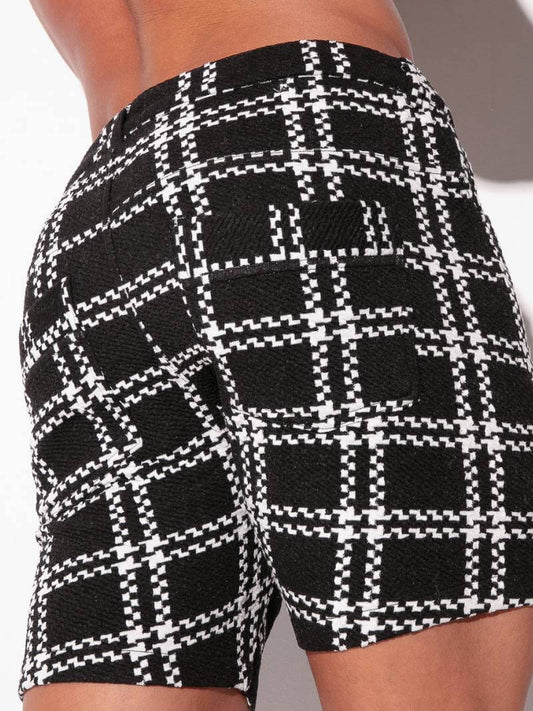 Black and white checkered shorts on a person against a neutral background