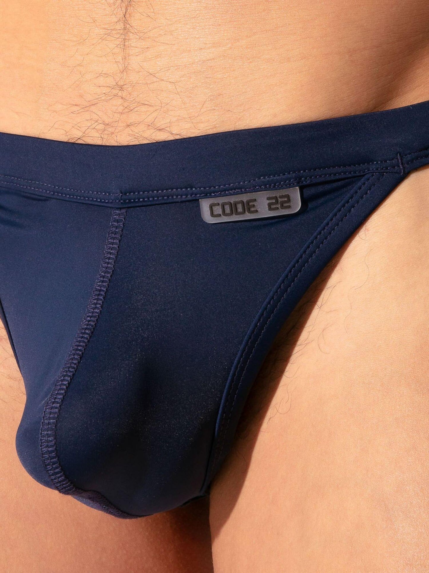 Navy blue men's underwear with 'CODE 22' label on a person wearing it.