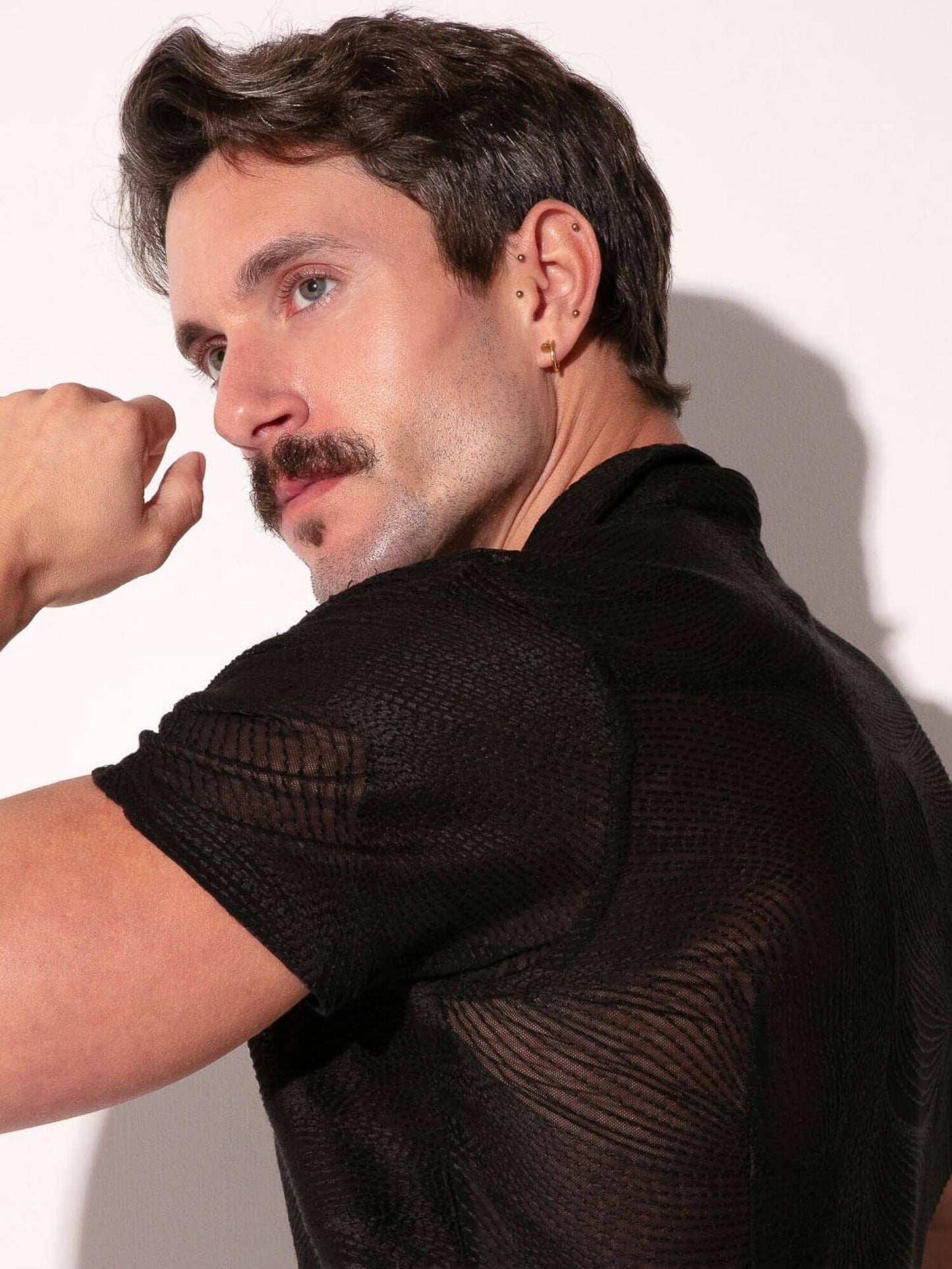 Man wearing a black textured shirt against a white background