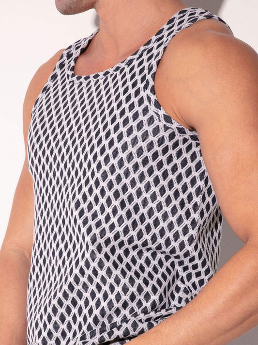 Person wearing a black and white patterned sleeveless top against a neutral background