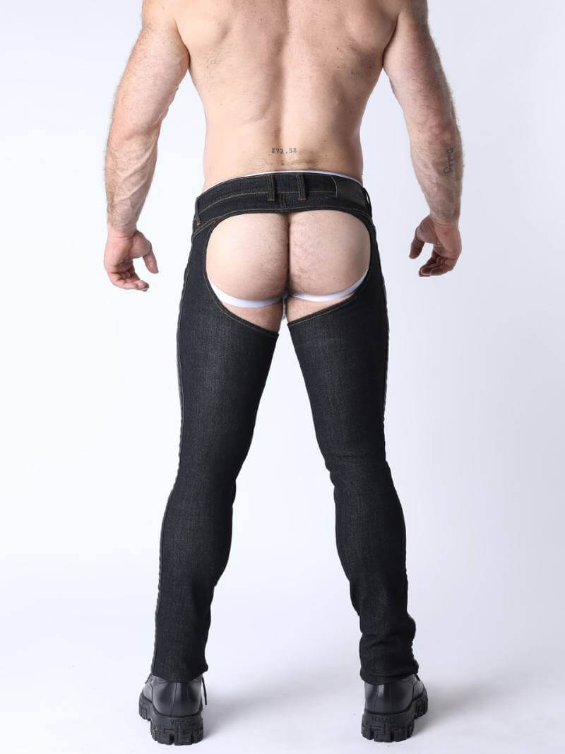 Person wearing black knee-high boots and a white thong on a plain background