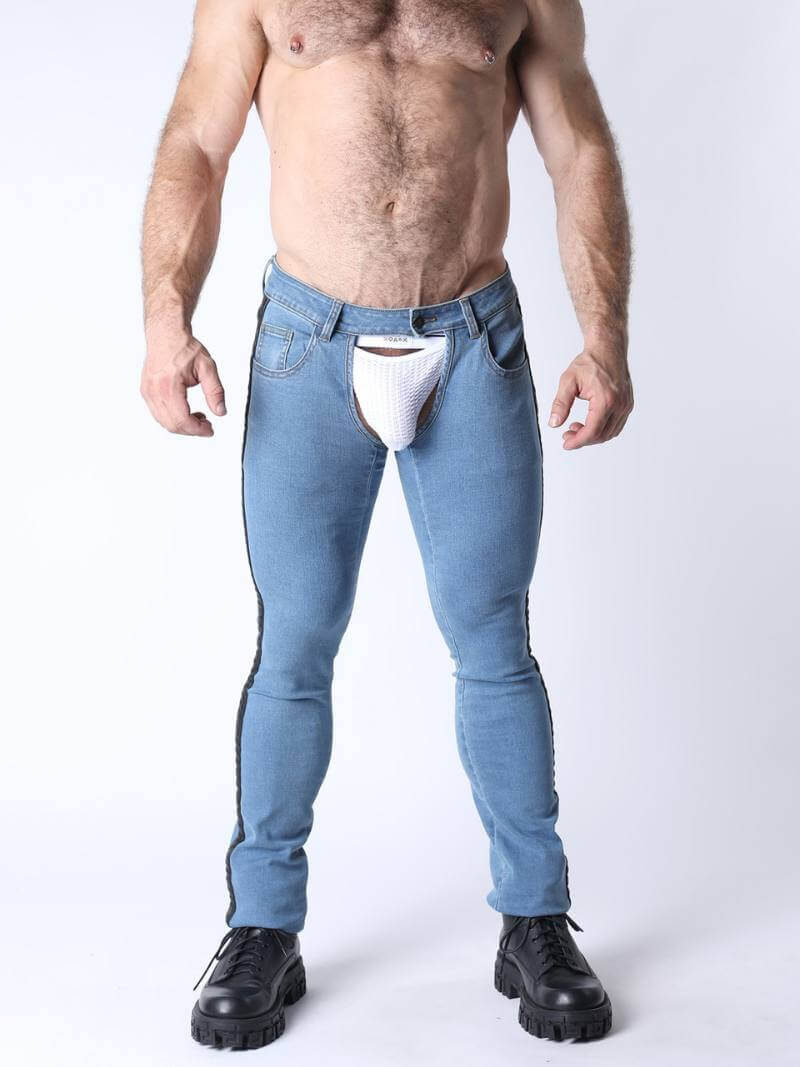 Man wearing light blue jeans with a white thong visible, on a plain background
