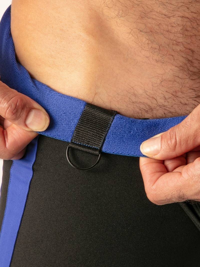 Person adjusting a blue waistband with a black buckle on a black garment.