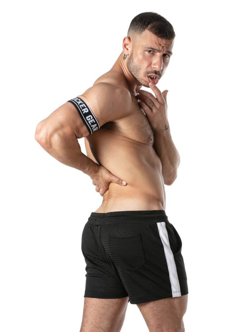 Man wearing black athletic shorts with a white stripe on a white background