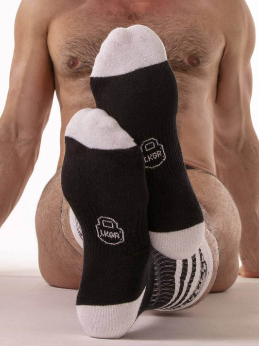 Black ankle socks with white accents on a plain background