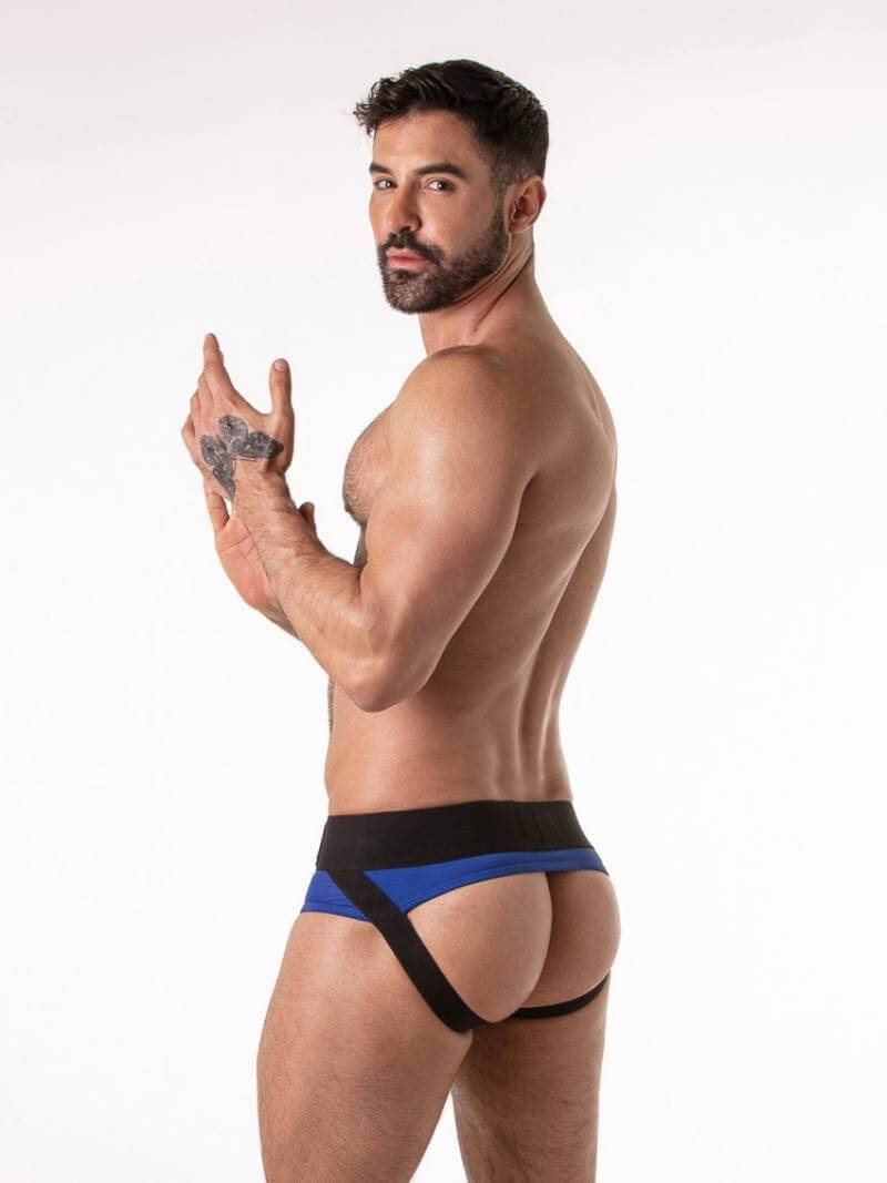 Man wearing a blue and black backless jockstrap brief against a white background