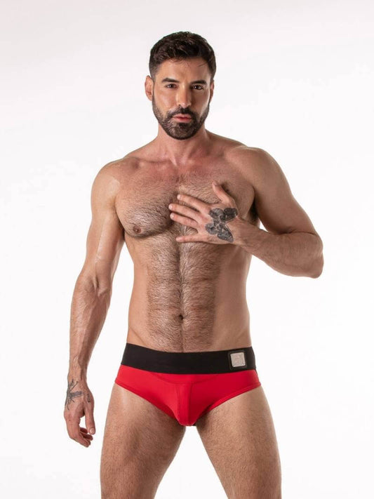 Man wearing red underwear with a black waistband on a white background