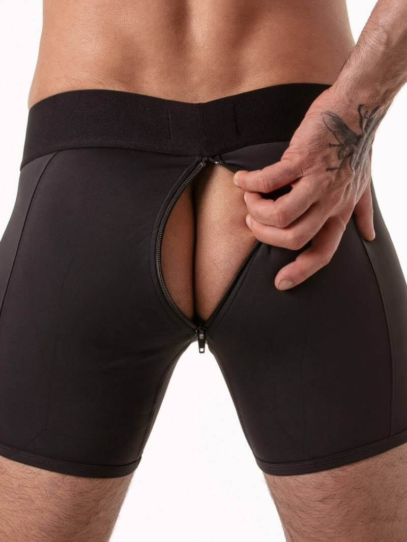 Black athletic shorts being adjusted by a person on a white background
