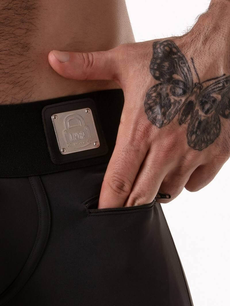 Person wearing black pants with a visible brand logo on a white background