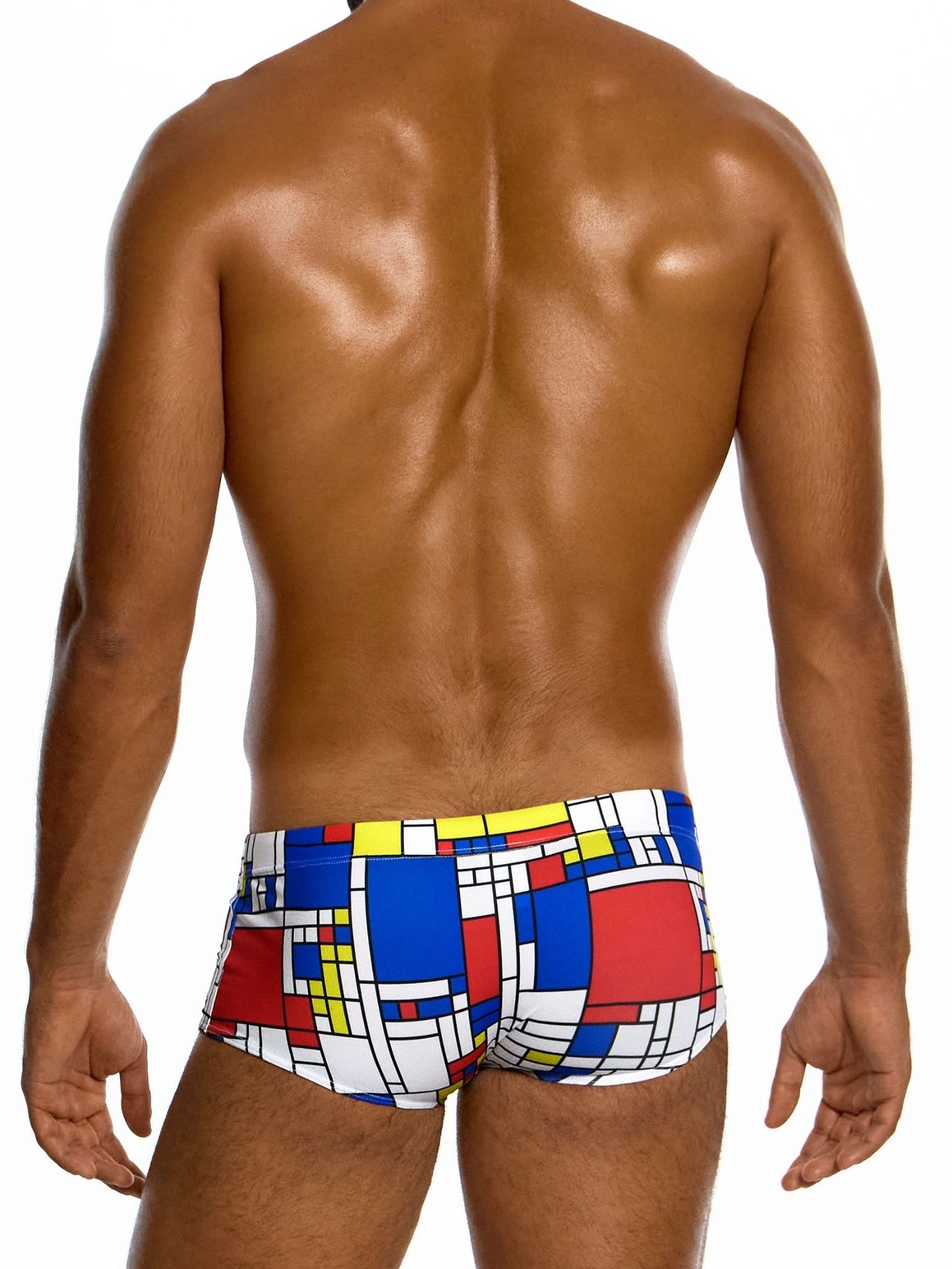 Man wearing colorful swim trunks with a geometric pattern on a white background