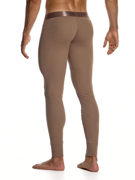 A man shown from the back wearing tight-fitting, full-length brown leggings or compression pants against a plain white studio background.