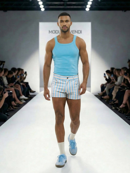 Model walking on a runway wearing a light blue tank top and shorts with a visible brand logo.