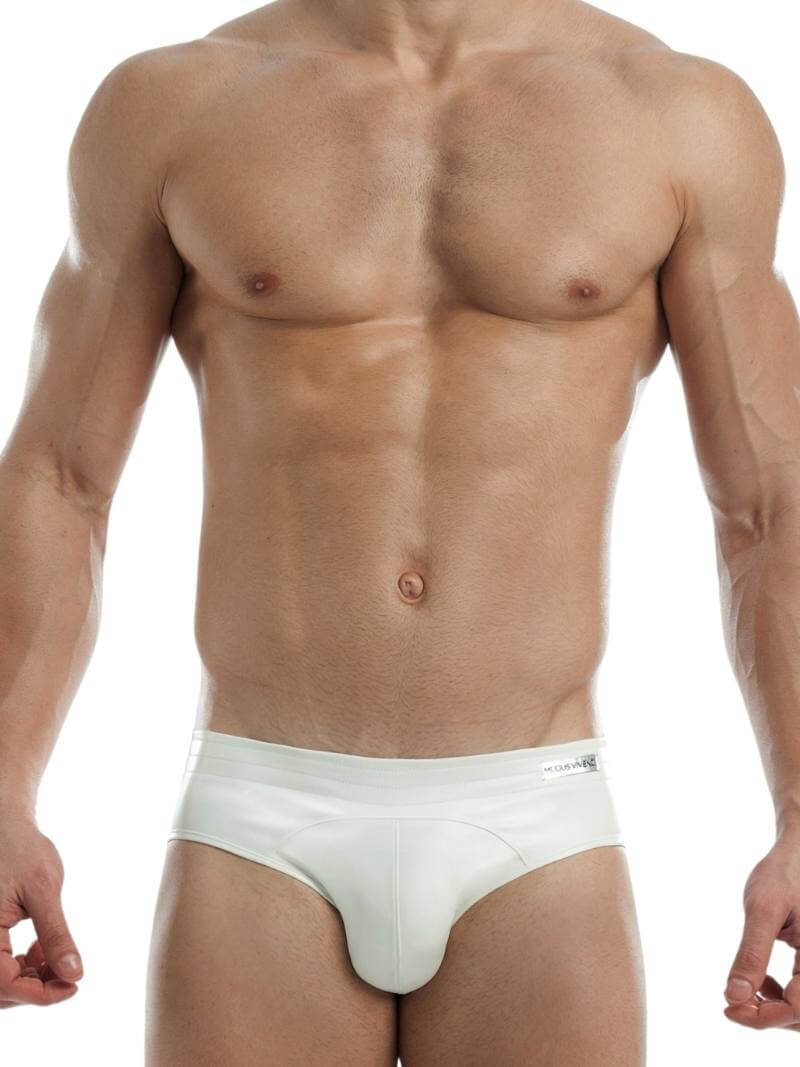 This image features a sleek, bottomless leather brief by Modus Vivendi, modeled by a fit, hairless man. The brief is designed with a colored body, accented by a matching stitching and waistband, which highlights the brand’s logo.