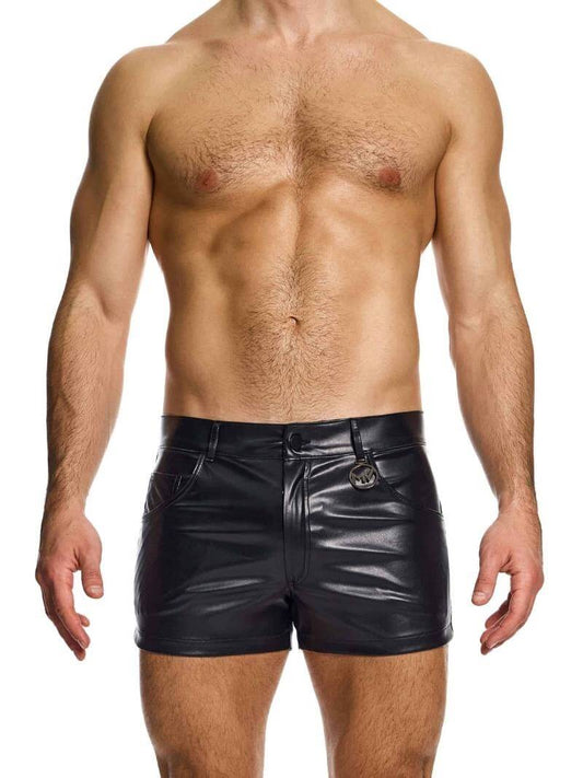 A man wearing black leather-look 5 pocket shorts with a metallic MV logo.