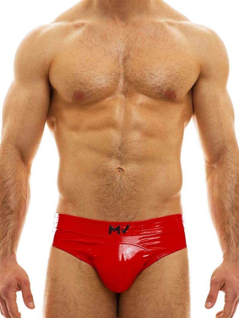 A man wearing a blue, shiny, bottomless PVC vinyl brief with an elasticated waistband and MV branding on the front.