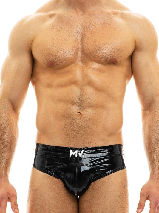 A model wearing blue PVC vinyl briefs with 'MV' branding on the waistband.
