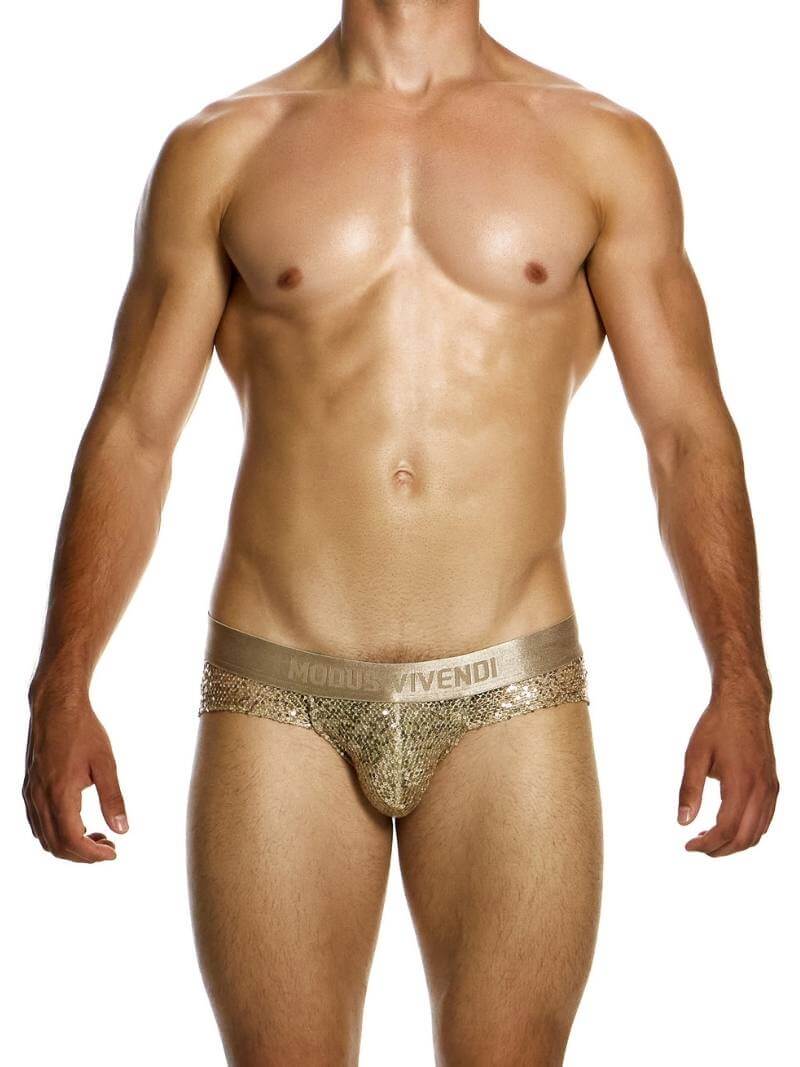 A model wearing a gold sequin-covered pouch jockstrap with a low-rise waistband.
