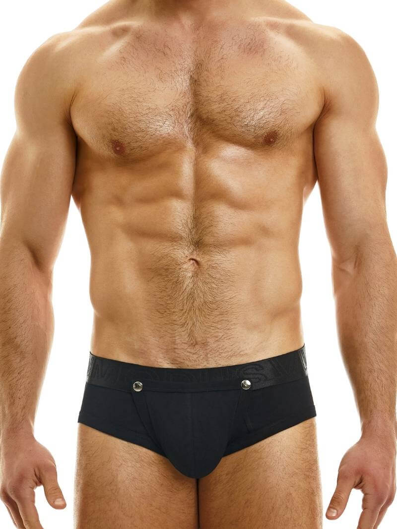 This image features a male model wearing the Modus Vivendi Hole Bottomless Brief, available in classic black, white, or grey colorways. The brief is designed with a backless style and a removable pouch, which is fastened with metal poppers and can be fully removed for a crotchless look.
