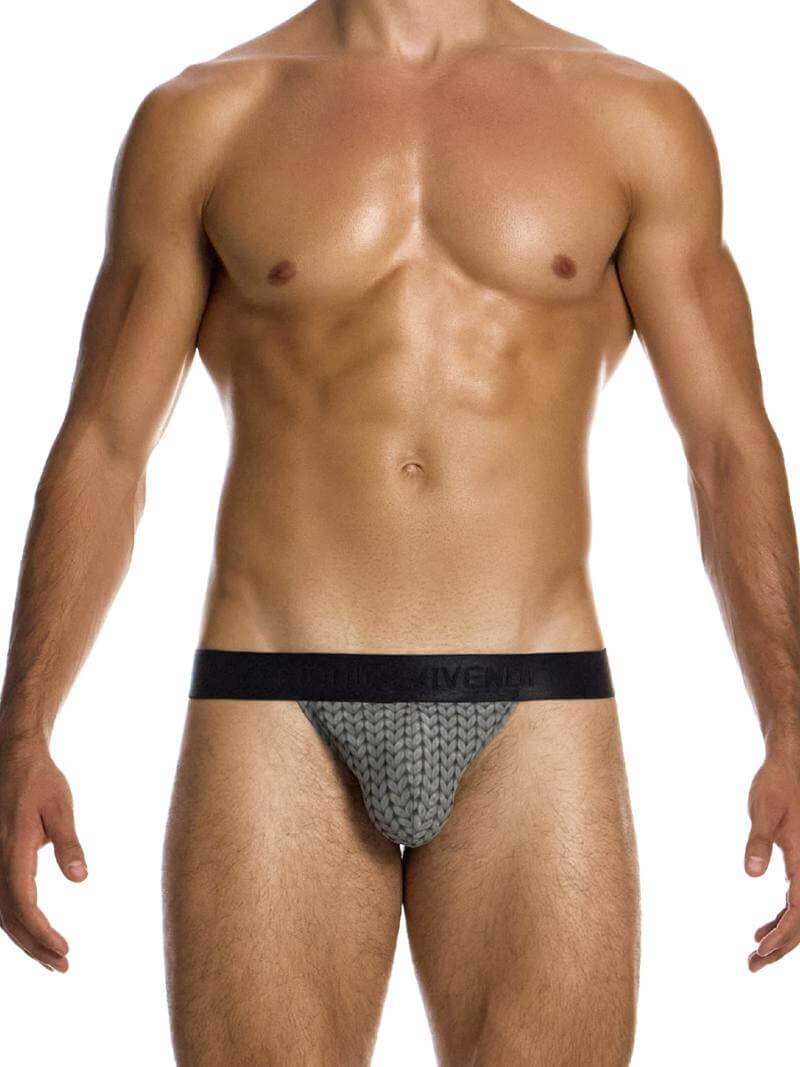 A male model wearing a Modus Vivendi Illusion Sheer Tanga with a two-tone contrasting color intricate print in black/grey, featuring a low-rise design and contoured pouch.