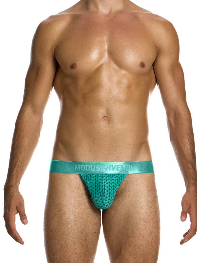 A male model wearing a Modus Vivendi Illusion Sheer Tanga with a two-tone contrasting color intricate print in black/grey, featuring a low-rise design and contoured pouch.