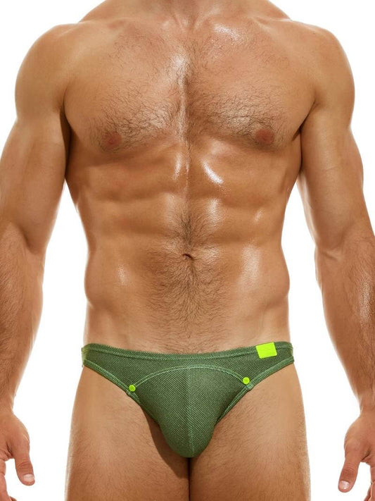 A man wearing a neon green 'MODUS VIVENDI Jeans Mini Swimming Brief' with decorative press studs and a silicone brand logo.