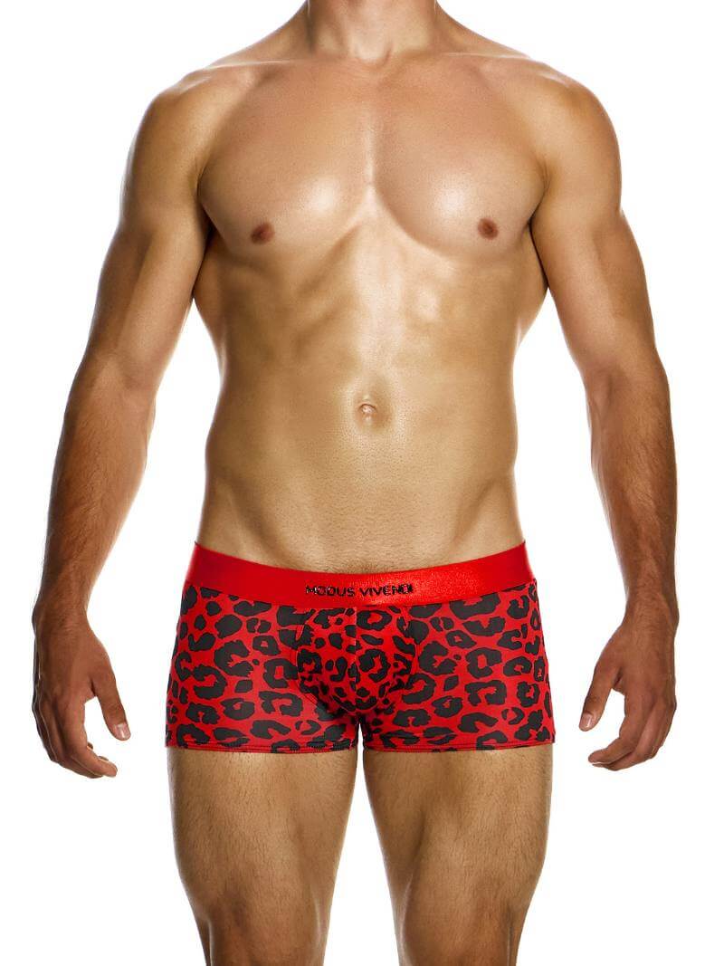 A model wearing red boxer briefs with a black leopard animal print design, featuring a shiny branded waistband and a low-cut waist.