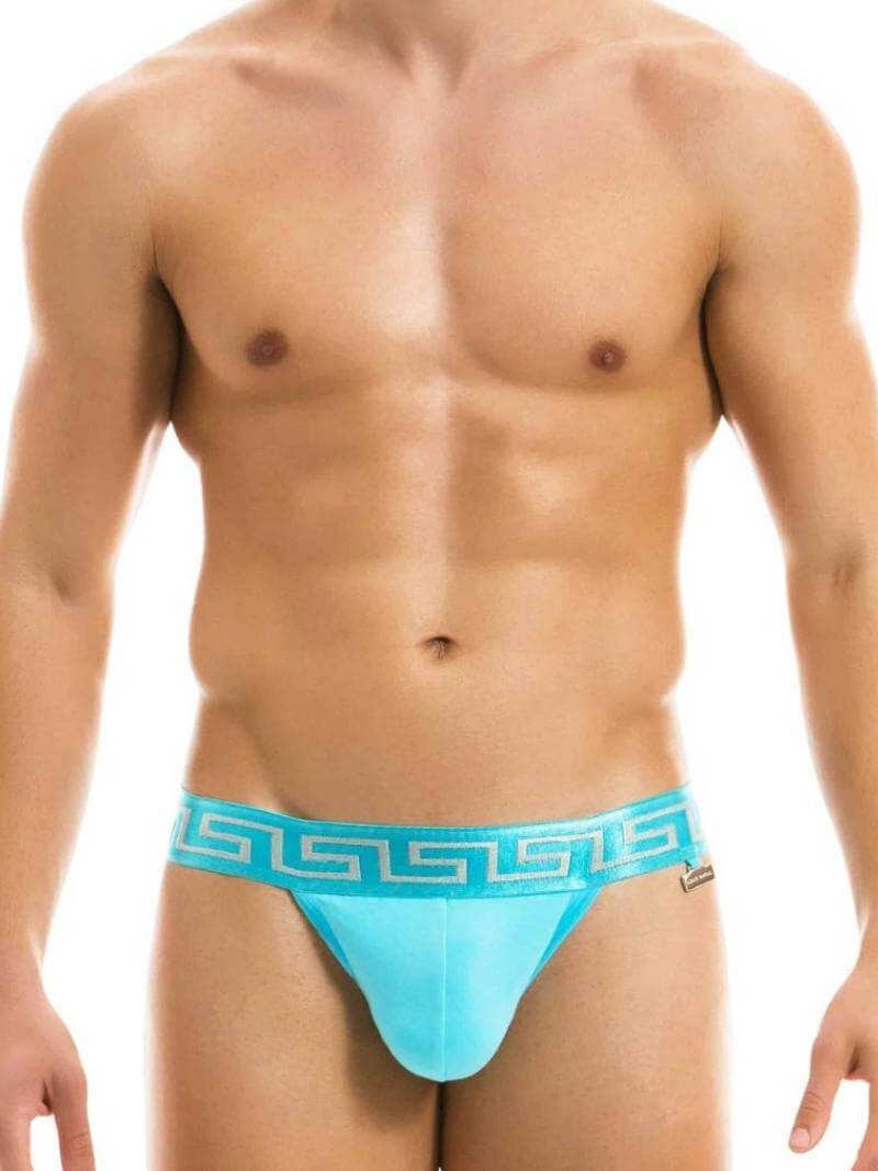 A model wearing a red jockstrap with a Meander Greek Key print waistband and a gold or silver Modus Vivendi charm logo.