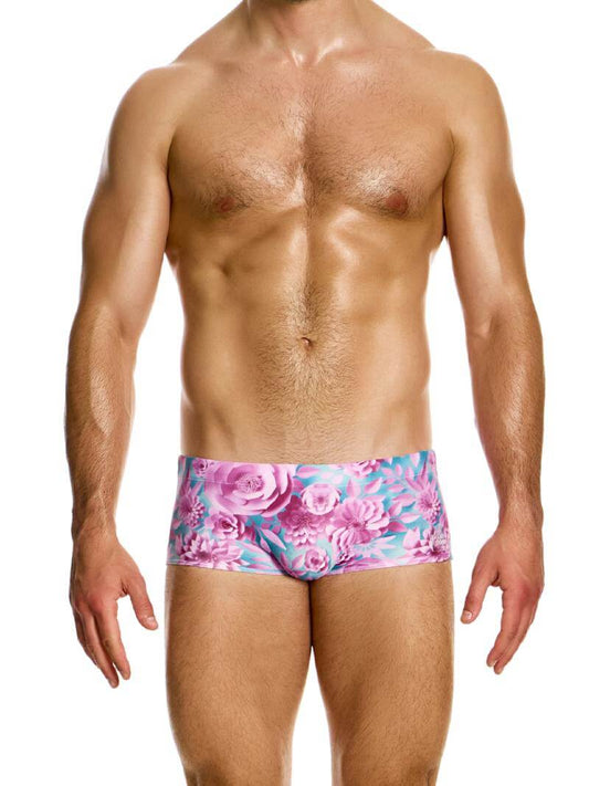 A model wearing a blue floral Modus Vivendi origami swim trunk with a Brazil cut, featuring a branded logo on the waistband.