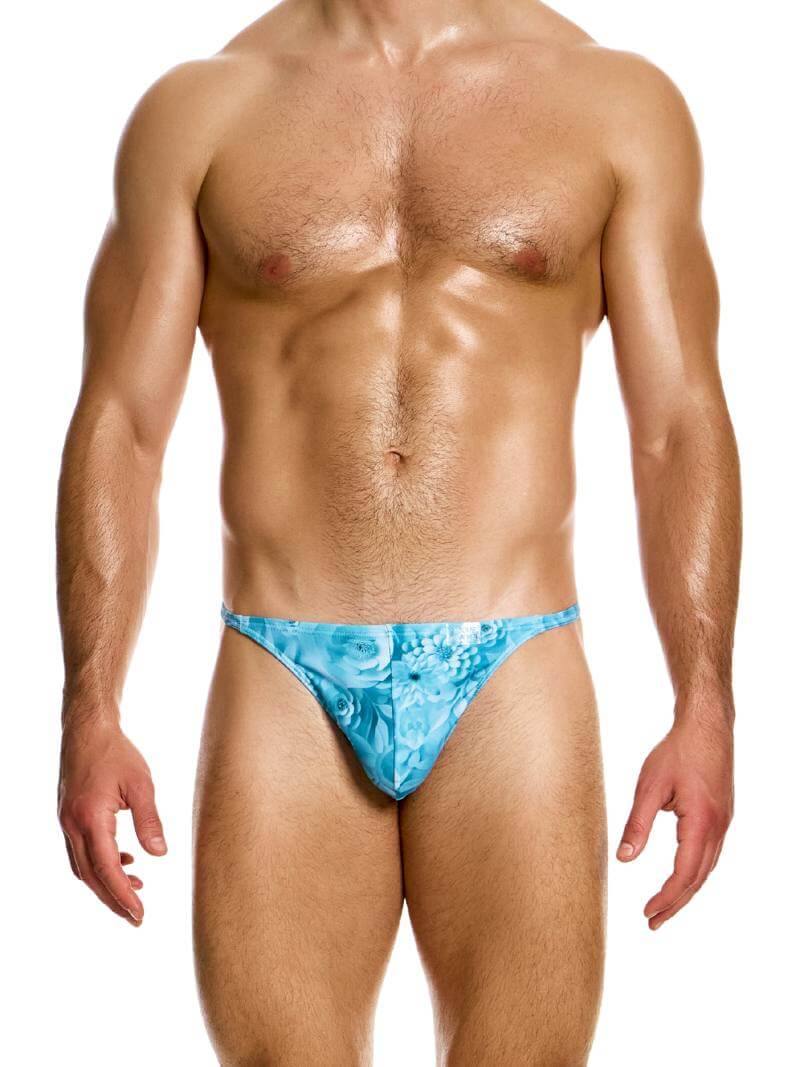 A male model wearing a Modus Vivendi Origami swimming thong with a blue and pink floral pattern.
