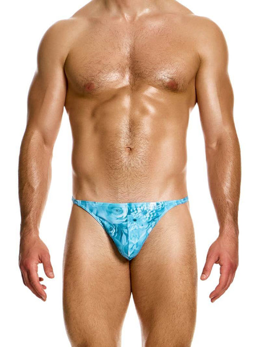 A male model wearing a Modus Vivendi Origami swimming thong with a blue and pink floral pattern.