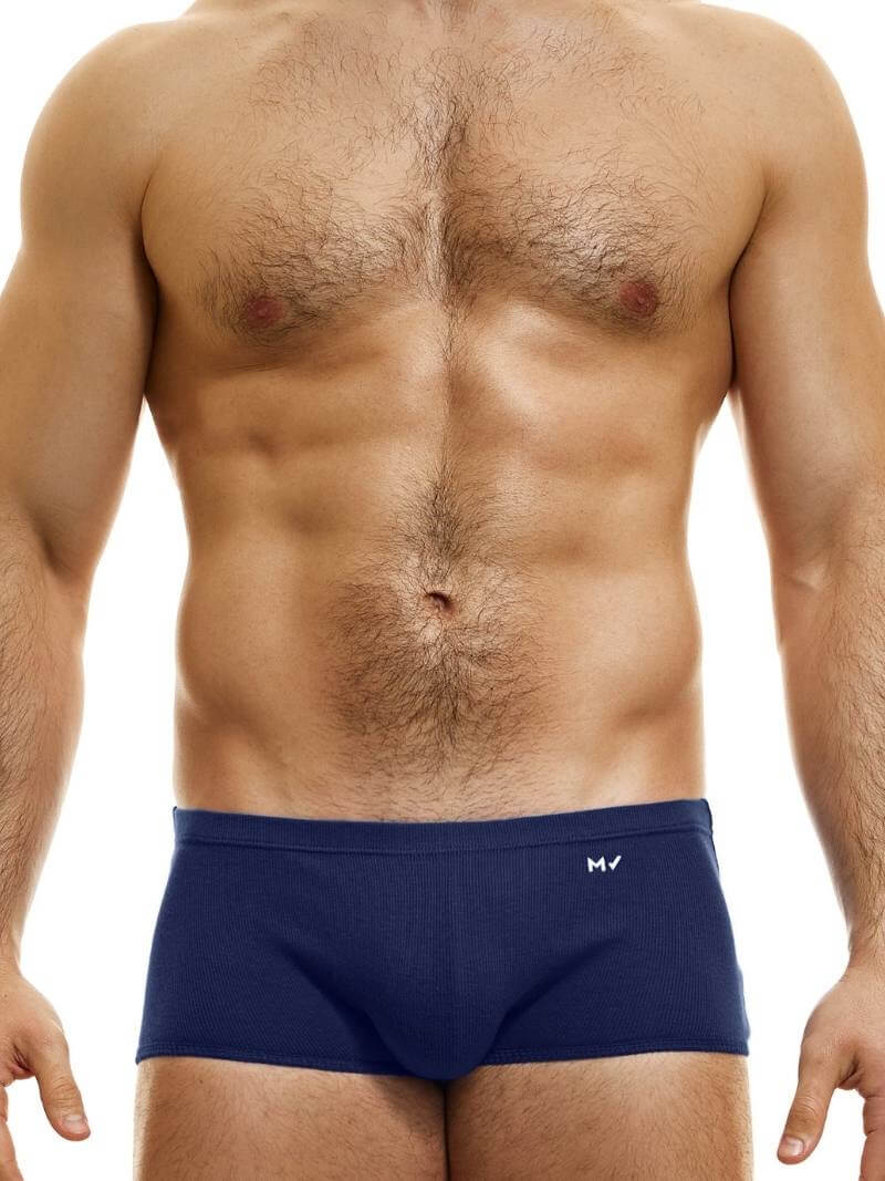 A model wearing blue Brazil-cut boxer underwear with a low-rise waistband and a small MV logo below the waistband.