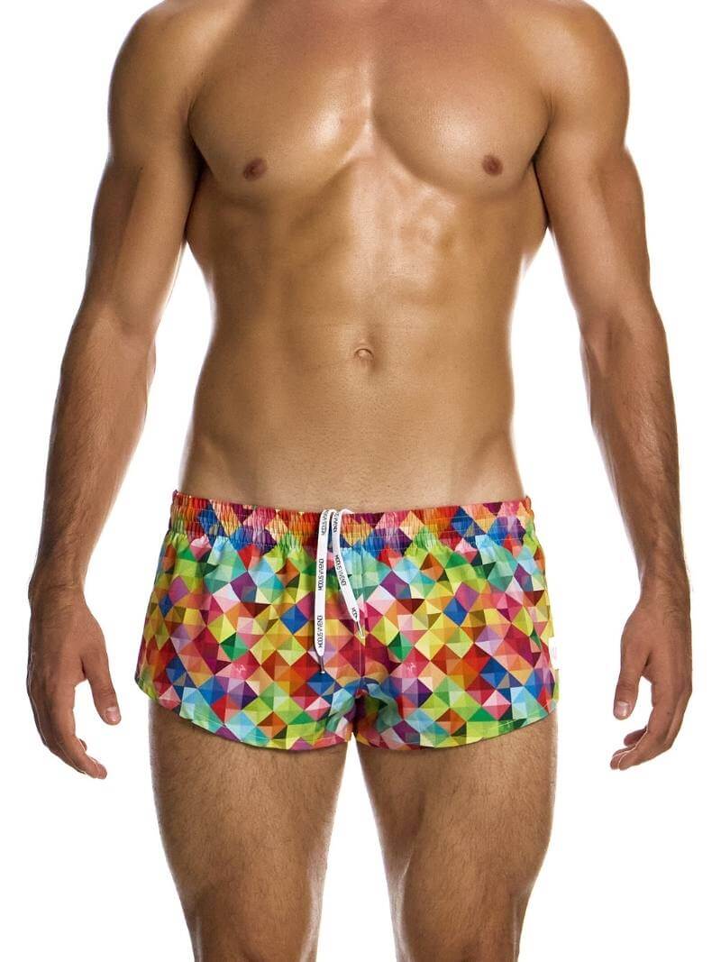 A pair of multicolored geometric patterned swimwear shorts with a Modus Vivendi logo, worn by a model.