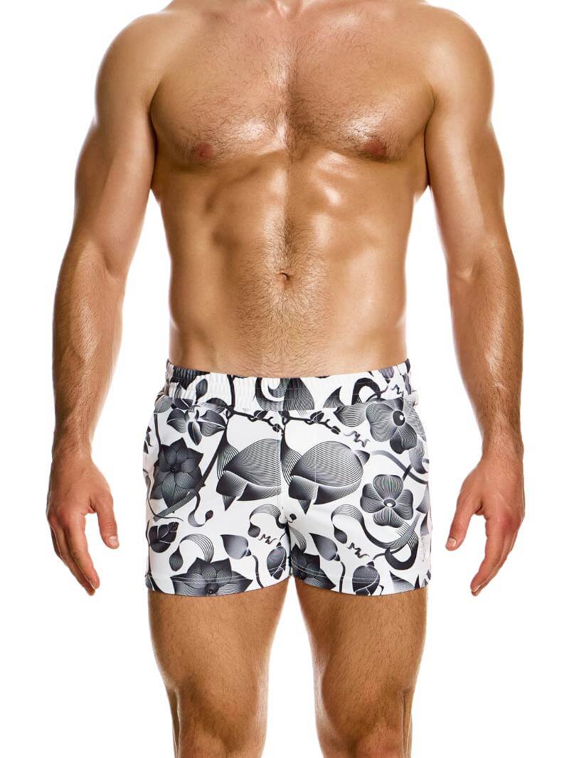 A pair of white swim shorts with a black floral print, featuring a low-rise elasticated waistband, side pockets, and a back patch pocket.