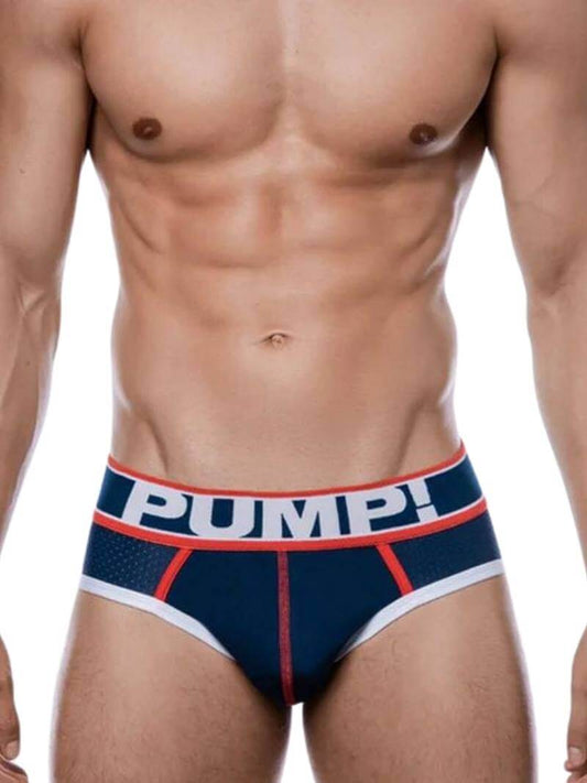 A man wearing a navy and red PUMP! branded micro mesh brief with white leg trims.
