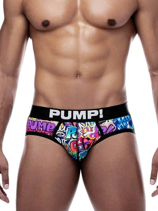 A model wearing a colorful graffiti-print full front jockstrap with black trims and a branded waistband that reads 'PUMP!'