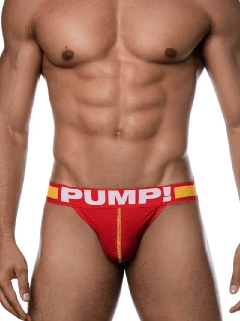 A man wearing a red and yellow PUMP! branded mesh jockstrap with a contour pouch.