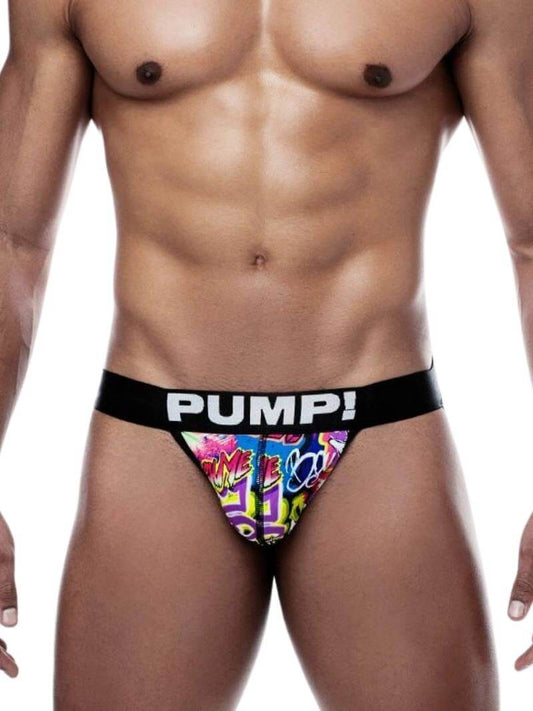 A man wearing a multicolored graffiti-print jockstrap with a black elastic waistband and the brand 'PUMP!' visible on the waistband.