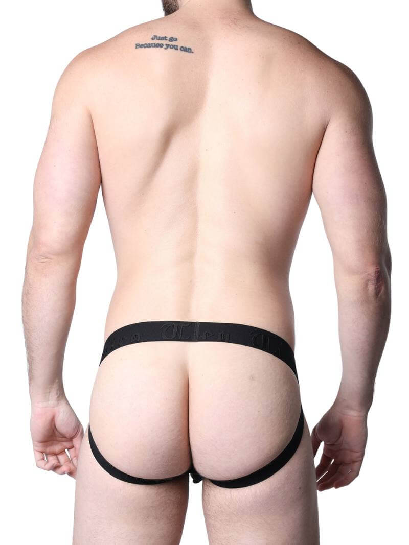 Man wearing a black lace lingerie set against a neutral background