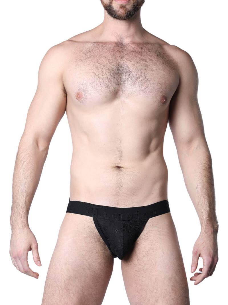 Man wearing a black lace lingerie set against a neutral background