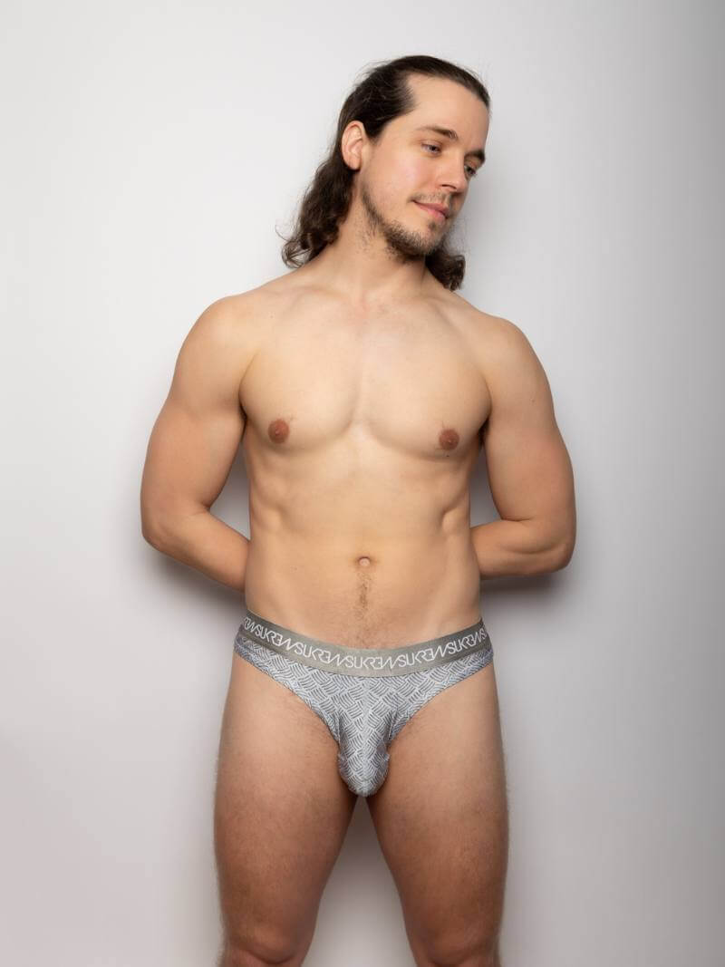 Man wearing a patterned underwear against a plain background