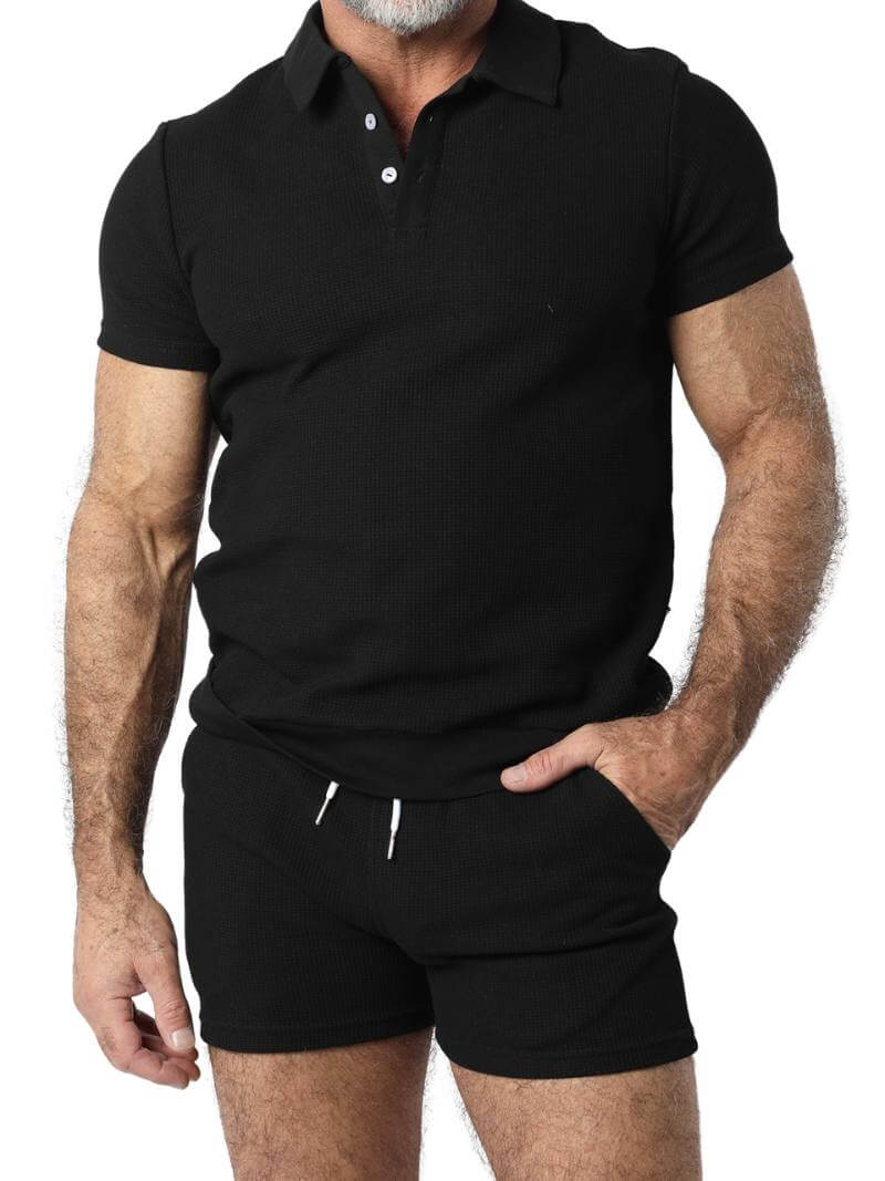 A man wearing mid-thigh length pink knitted shorts with a drawstring waist.